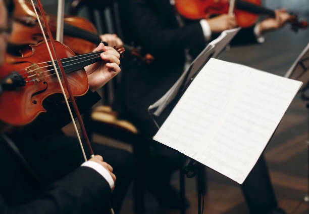 istock Elegant string quartet performing at wedding reception in restaurant, handsome man in suits playing violin and cello at theatre play orchestra close-up, music concept 1214225938