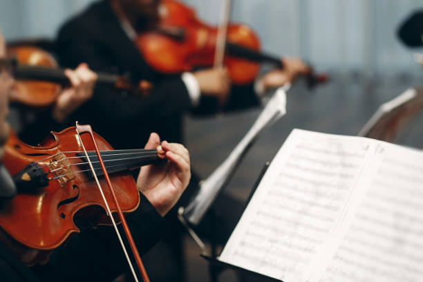 istock Elegant string quartet performing at wedding reception in restaurant, handsome man in suits playing violin and cello at theatre play orchestra close-up, music concept 1214226264