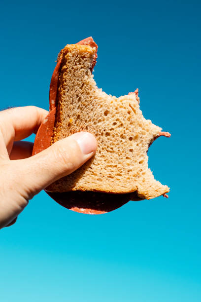 istock bitten vegan salami sandwich in the hand 1214226523