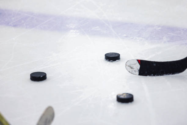 istock Black old ice hockey puck on ice rink. 1214226740
