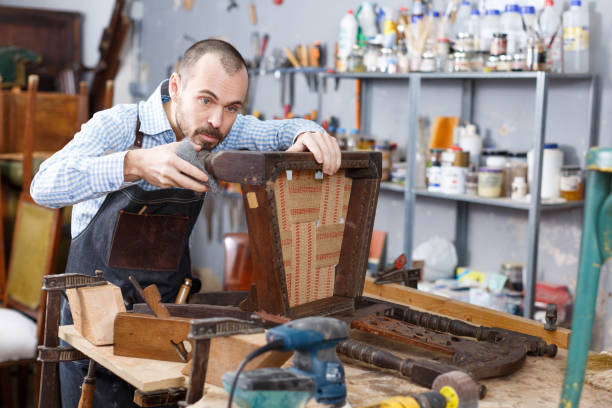 istock Artisan inspecting old chair 1214228580