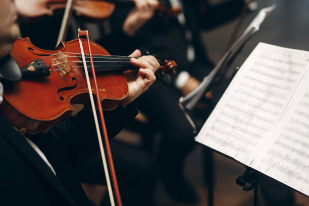 istock Elegant string quartet performing at wedding reception in restaurant, handsome man in suits playing violin and cello at theatre play orchestra close-up, music concept 1214229122