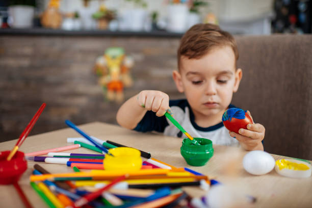 istock Little boy painting Easter eggs stock photo 1214230200