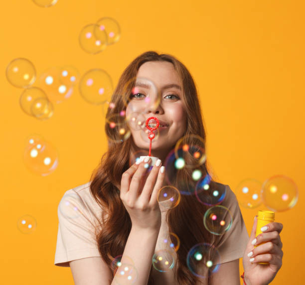 istock young woman blowing soap bubble 1214231350
