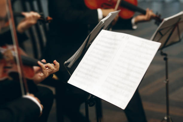 istock Elegant string quartet performing at wedding reception in restaurant, handsome man in suits playing violin and cello at theatre play orchestra close-up, music concept 1214231904