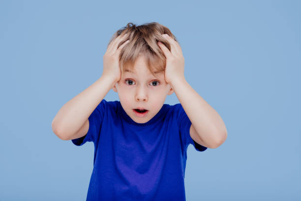 istock astonished little boy with hands on head looks at camera 1214232279