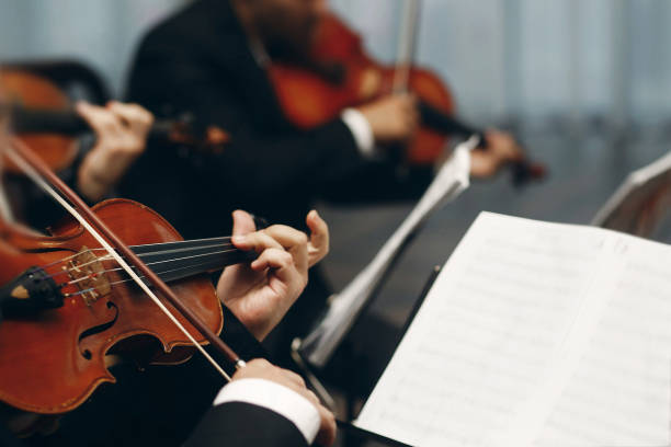 istock Elegant string quartet performing at wedding reception in restaurant, handsome man in suits playing violin and cello at theatre play orchestra close-up, music concept 1214232753