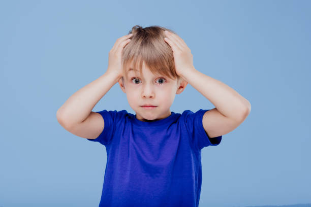 istock amazed little boy with hands on head looks at camera 1214232766