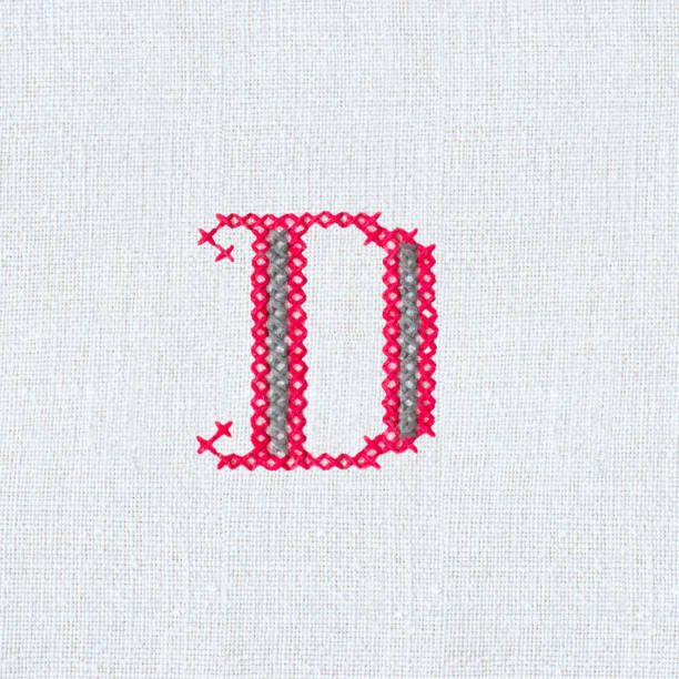 istock Vintage cross-stitch letter D on linen fabric 1214235599
