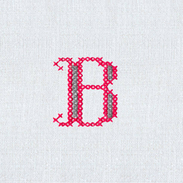 istock Vintage cross-stitch letter B I on linen fabric 1214235621
