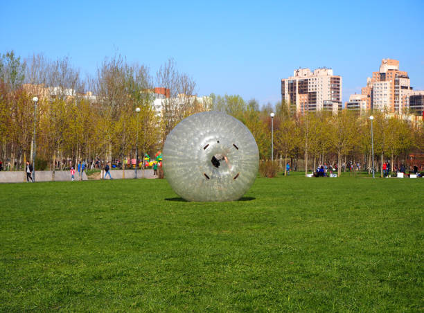 A giant bubble balloon for outdoor inflatable games with a person inside it, zorbing Saint Petersburg, Russia, 05.01.2019. A giant bubble balloon for outdoor inflatable games with a person inside it, zorbing - editorial zorbing stock pictures, royalty-free photos & images