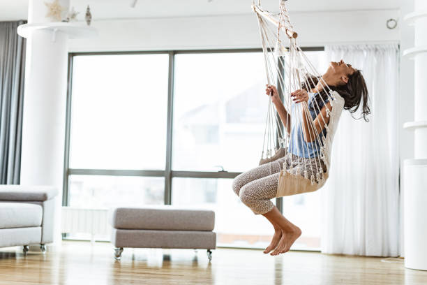 istock Carefree woman having fun while swinging at home. 1214236515