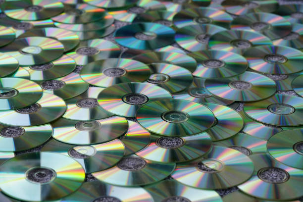 вид высокого угла разноцветных тонированных cd/dvd в виде текстурированного фона - repetition cd dvd data стоковые фото и изображения