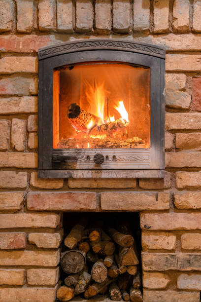 istock Burning fireplace with wooden logs and flame inside. Warm light, romantic atmosphere indoor 1214242085