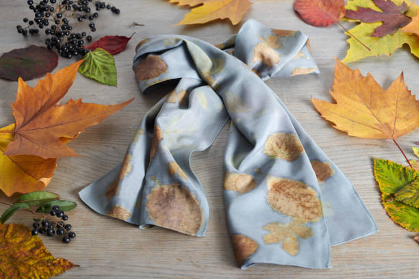 istock Hand-dyed silk scarf surrounded by berries and autumn leaves. Eco-print technique 1214242510