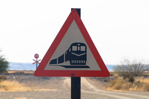 Train traffic sign with a locomotive and steam left behind on a triangle signboard. Rough and rusty, isolated on white background.