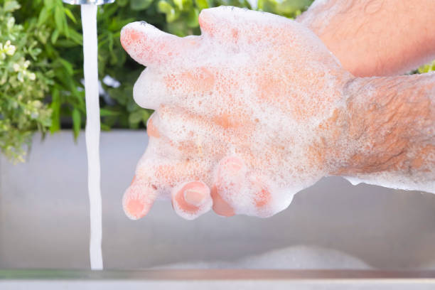 istock Male hands being washed at a sink outdoors 1214245535