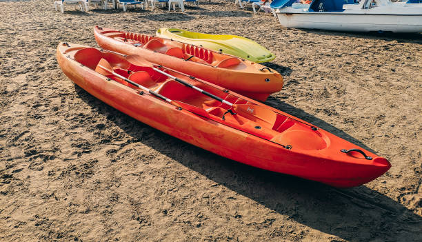 istock yellow and orange kayaks parked on the beach. summer activity 1214245644