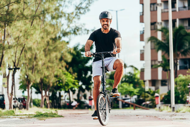 istock Young man cycling in the park on sunny day 1214248622