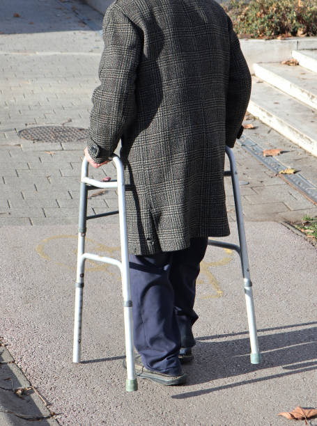 istock Old man walks on the street with a walker 1214248662