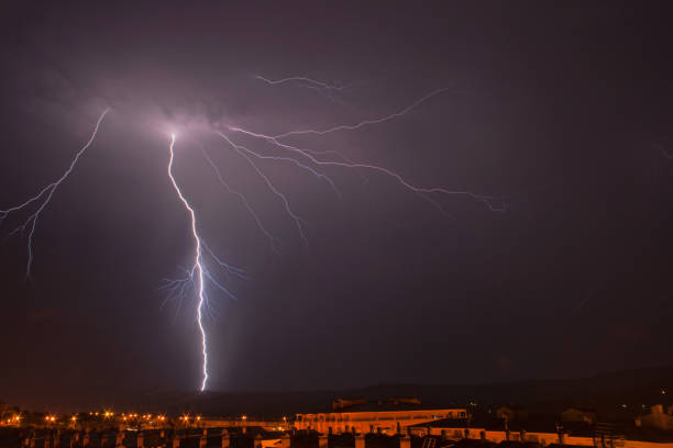 istock lightning strikes a city during a stormy night 1214249719