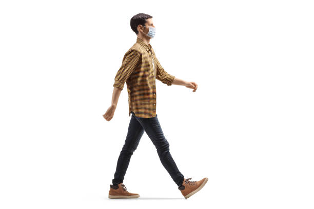 Man wearing a protective medical face mask and walking