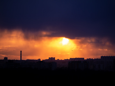 Cityscape silhouette under dark stormy sky