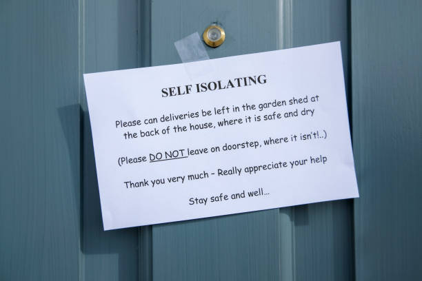 istock Self isolating sign on someones front door 1214254550