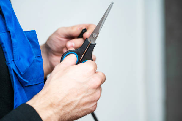 istock Professional window repair and installation technician, cuts sealing rubber for installation in a pvc window 1214255635