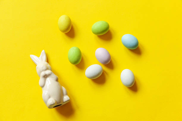 istock Happy Easter concept. Preparation for holiday. Easter candy chocolate eggs sweets and bunny toy isolated on trendy yellow background. Simple minimalism flat lay top view copy space 1214257186