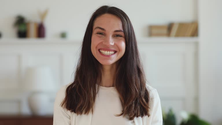 Cheerful millennial woman looking at camera laughing with dental smile