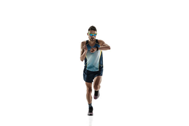 Triathlon male athlete running isolated on white studio background. Caucasian fit jogger, triathlete training wearing sports equipment. Concept of healthy lifestyle, sport, action, motion. Time check.