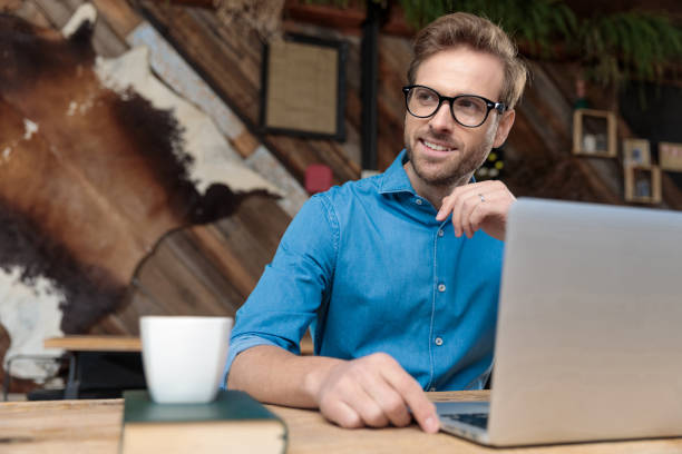 istock businessman working on laptop while looking away happy 1214259684