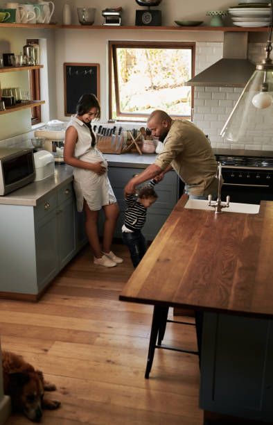 Show me your dancing skills! Shot of a young family spending quality time in the kitchen at home baby boy dancing with his mommy stock pictures, royalty-free photos & images