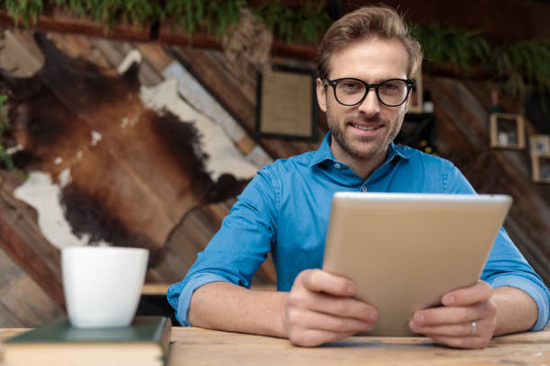 istock casual man holding tablet while looking at camera happy 1214263141