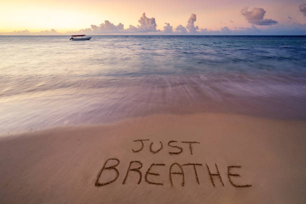 escrito a mano sólo respira en la playa de arena - breathe fotografías e imágenes de stock