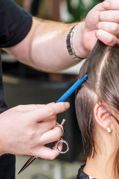 istock Hairdresser combs hair. 1214263717
