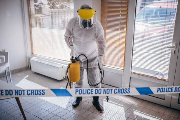 istock Man in protective suit disinfecting and spraying coronavirus infected room building 1214263737