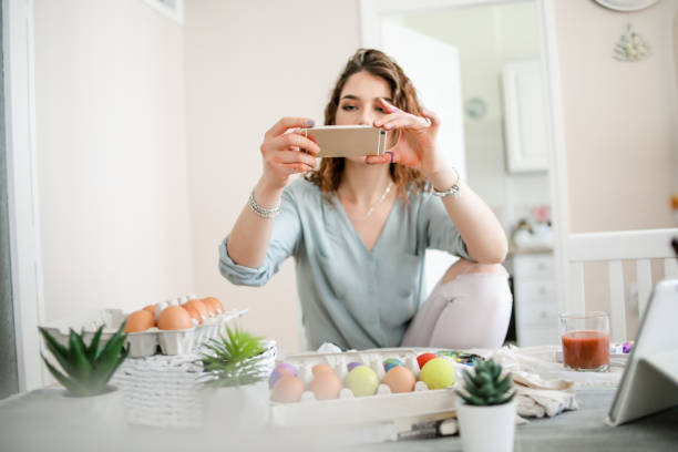 istock Woman decorating easter eggs in home 1214268181