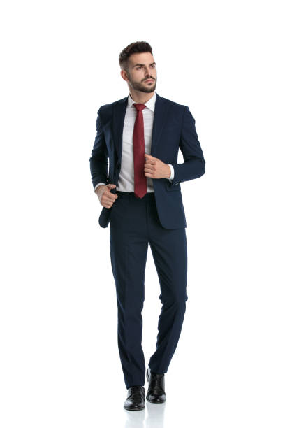 istock businessman walking while fixing jacket and looking away with attitude 1214269951