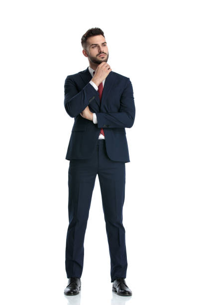 istock businessman standing with arms folded and touching chin pensive 1214270185