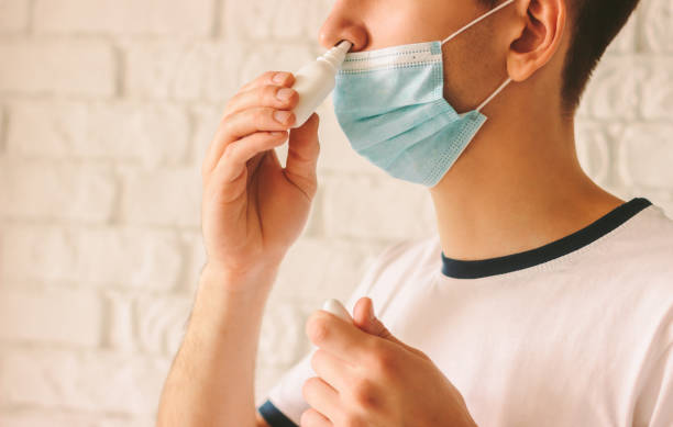 istock Sick man using nasal drops for his runny nose 1214272766