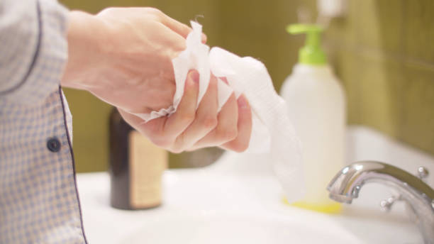 istock Young woman wiping hands with a disposable towel 1214274967