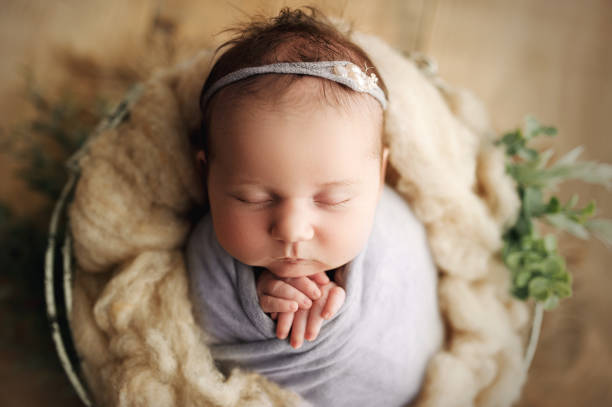 Neonata ragazza avvolta nel cestino degli oggetti di scena - foto stock