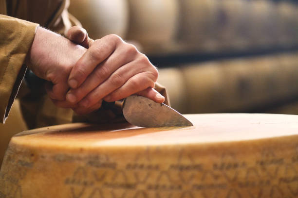 close up of a cheesemaker is controlling the seasoning of parmesan cheese, which was maturing - milk european alps agriculture mountain imagens e fotografias de stock