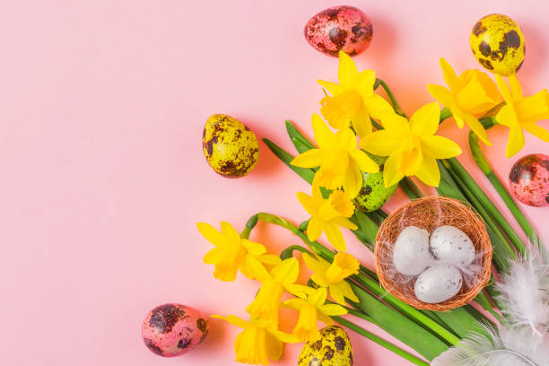 istock Easter background with Easter eggs and spring narcissus flowers on pastel pink background. flat lay. top view 1214277304