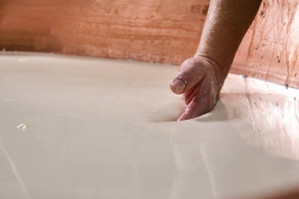 Close up of a cheesemaker is preparing  a form of Parmesan cheese using fresh and biologic milk Close up of a cheesemaker is preparing  a form of Parmesan cheese using fresh and biologic milk following the ancient Italian tradition in a dairy factory. dairy producer stock pictures, royalty-free photos & images