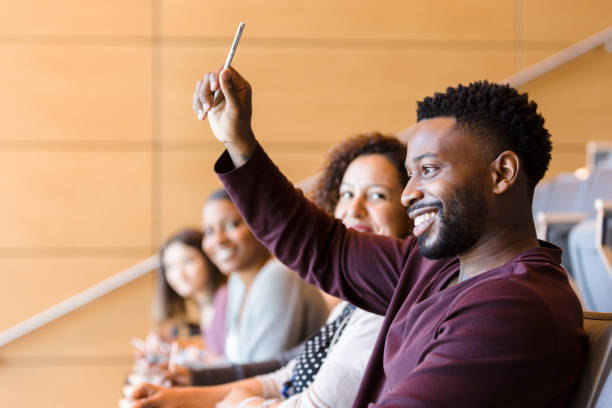 african american student raises his hand during class - lecture hall university student seminar imagens e fotografias de stock