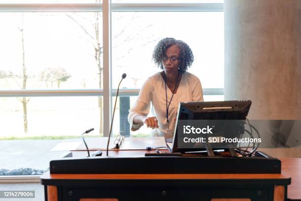 Mature Female College Professor Prepares For Class Stock Photo - Download Image Now - Professor, Teacher, Lecture Hall