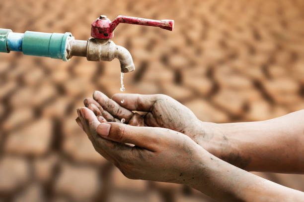 Drought and water scarcity Hand of people wating for a drip of water from a faucet at desert. Climate change, water scarcity and crisis concept. water crisis stock pictures, royalty-free photos & images